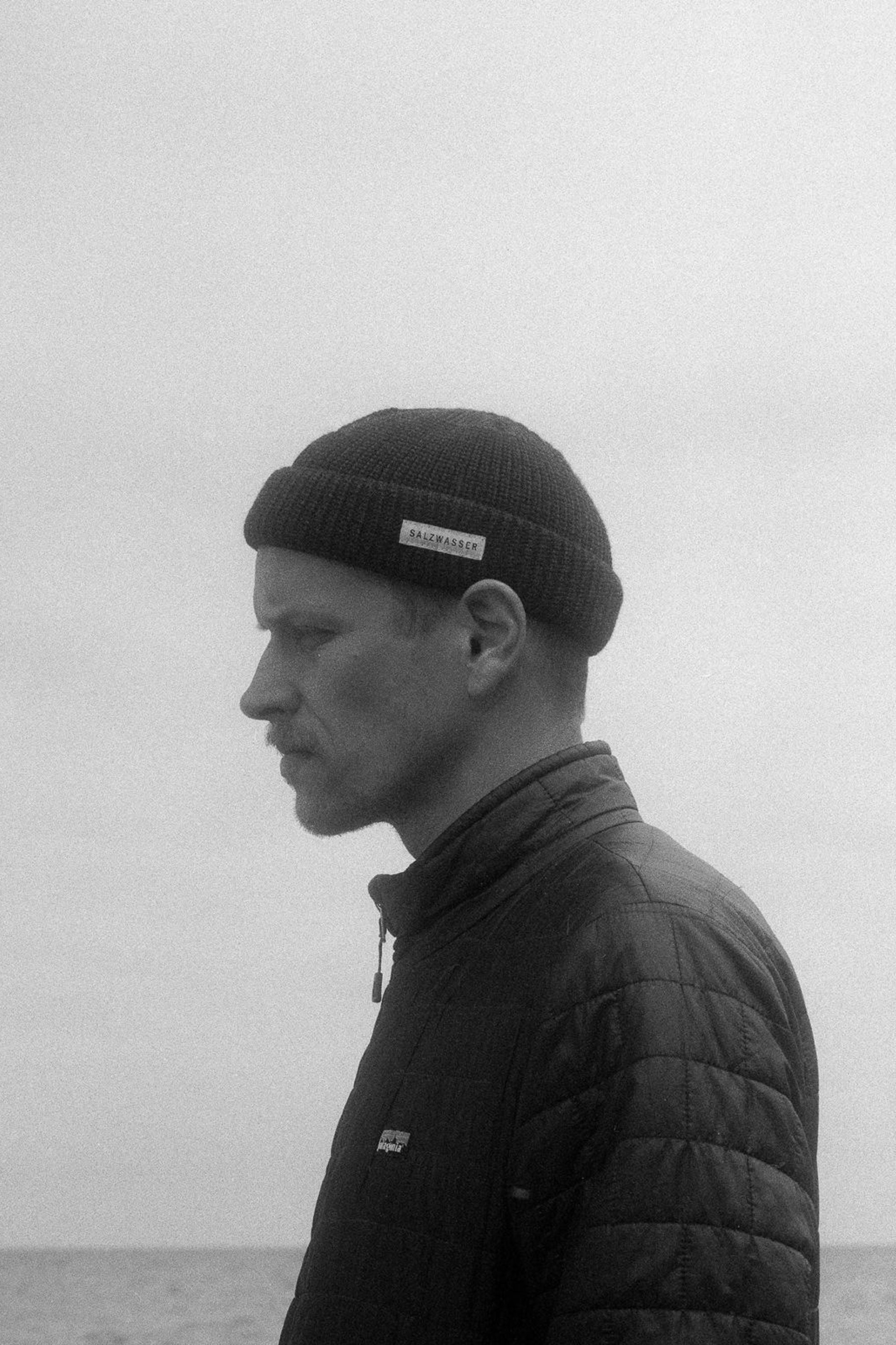 Mann trägt Beanie aus Merinowolle an der Ostsee