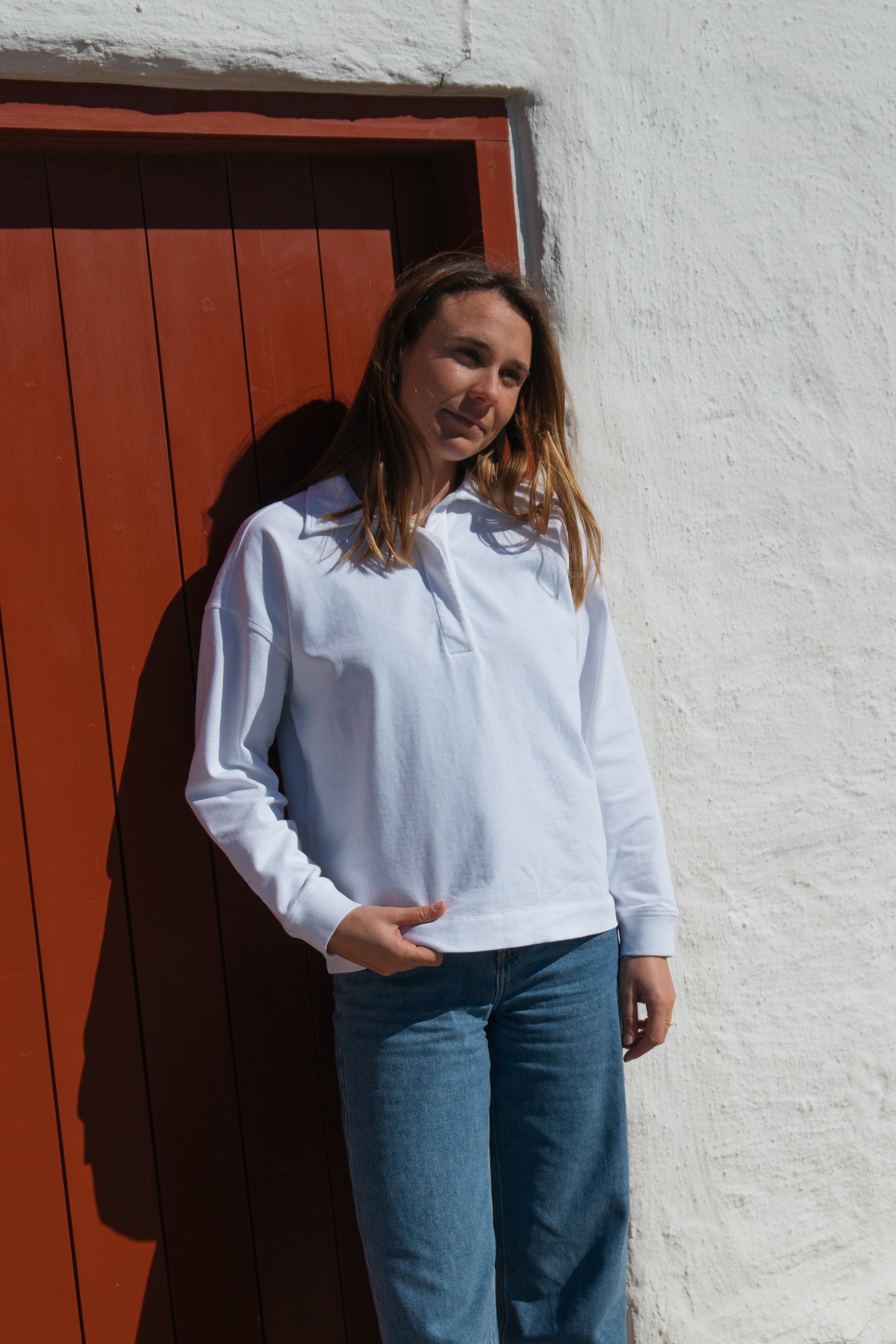 Frau trägt GOTS-zertifiziertes weißes Polo Longsleeve von SALZWASSER _women