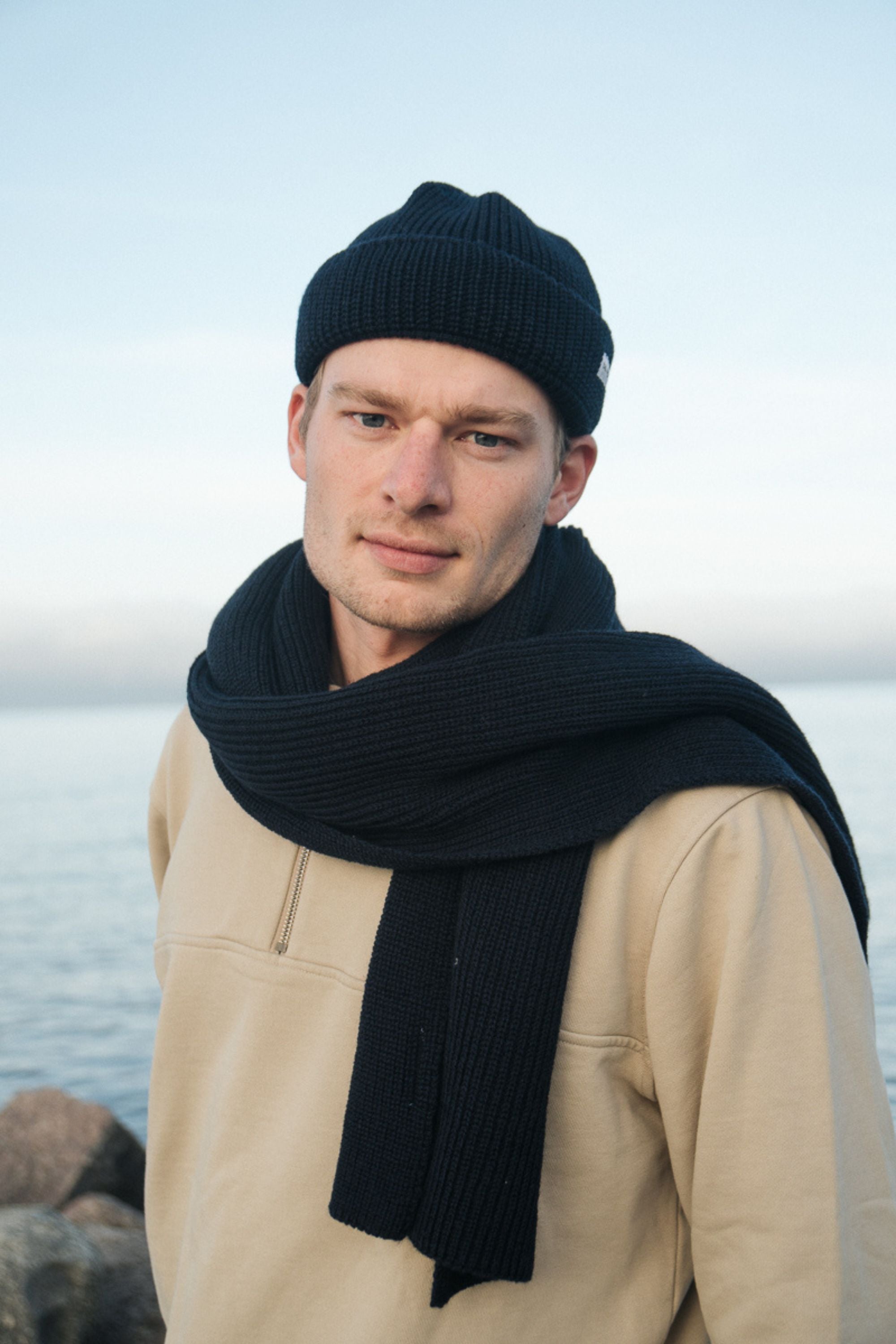 Mann trägt nachhaltigen Schal und Strickmütze aus Merinowolle
