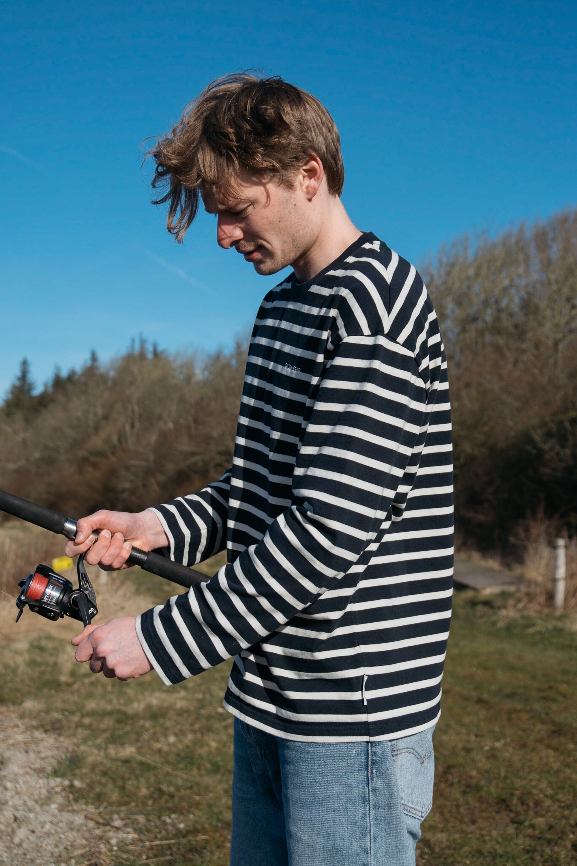 Mann trägt gestreiftes Langarmshirt von SALZWASSER in naturweiß-marine _men _women