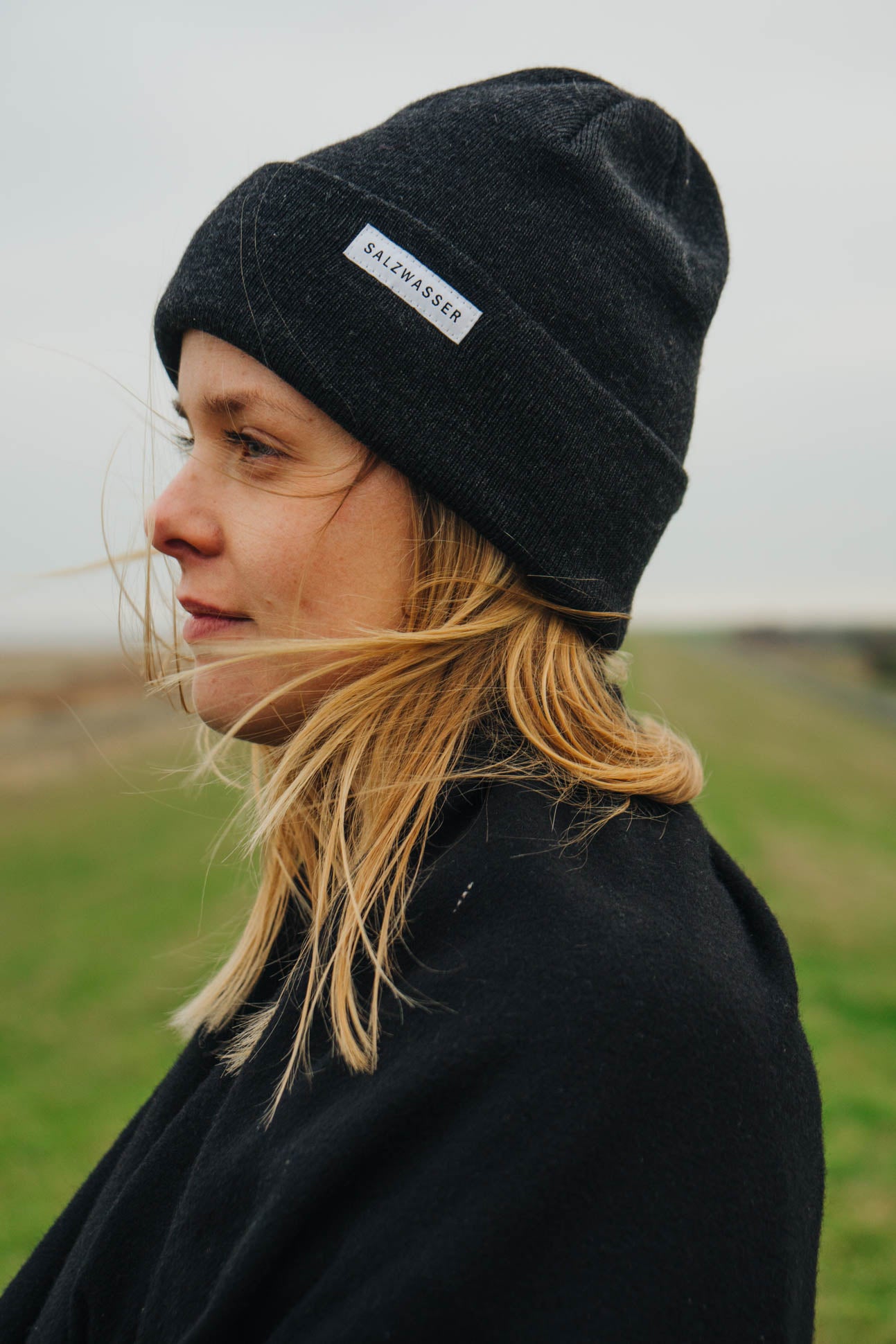 Frau trägt fair produzierte SALZWASSER Mütze in anthrazit in der Natur